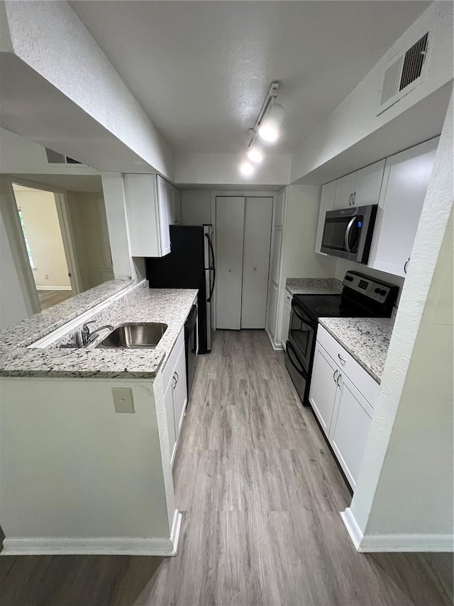 kitchen featuring white cabinetry, black range with electric stovetop, kitchen peninsula, and light stone counters