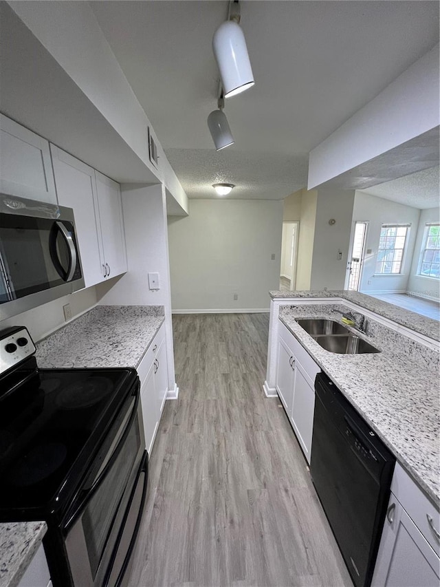 kitchen featuring stainless steel appliances, light hardwood / wood-style floors, sink, and white cabinets