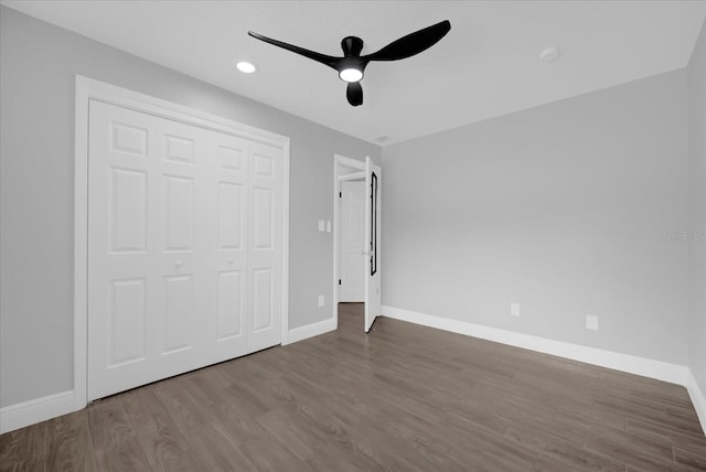 unfurnished bedroom featuring hardwood / wood-style flooring, ceiling fan, and a closet