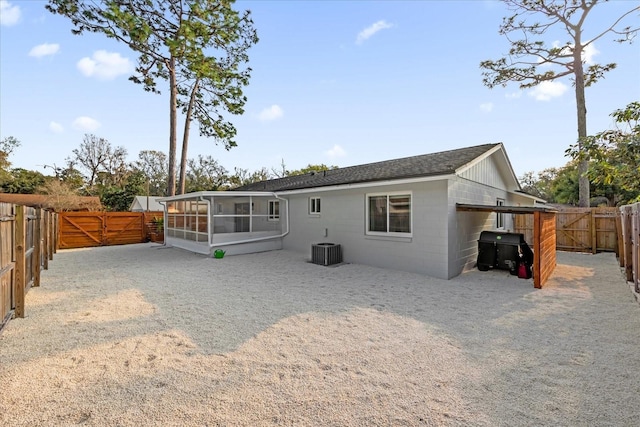 back of property with a sunroom and central air condition unit