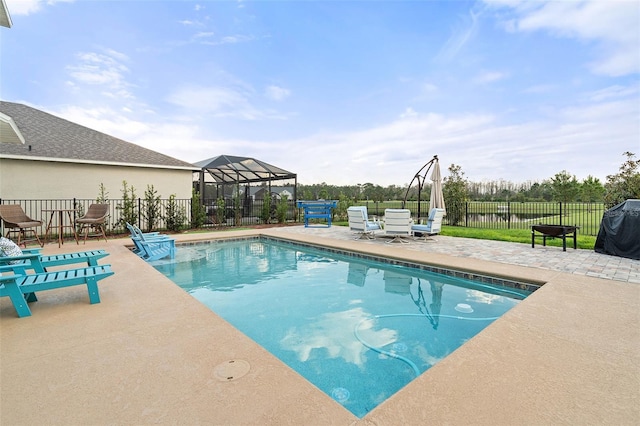 view of pool with grilling area, a lanai, and a patio area