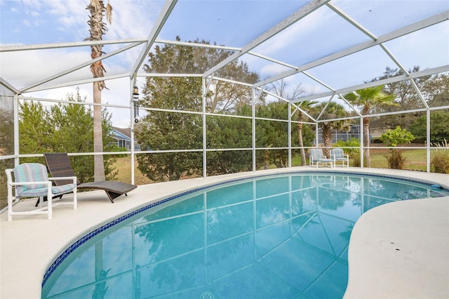 view of pool with a patio area and glass enclosure