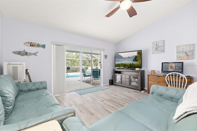 living room featuring a textured ceiling, vaulted ceiling, ceiling fan, and light wood-type flooring