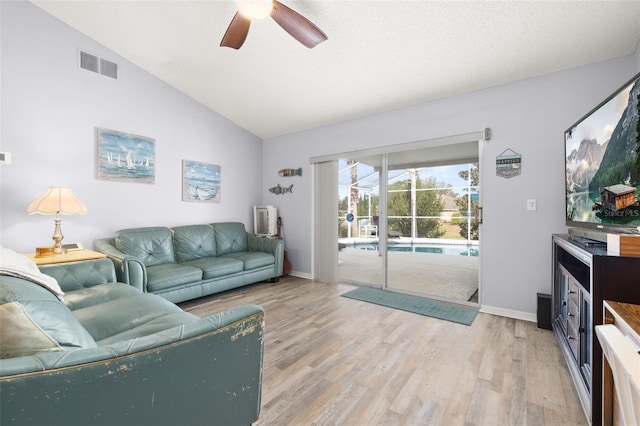 living room with ceiling fan, vaulted ceiling, and light hardwood / wood-style flooring