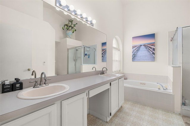 bathroom with vanity and shower with separate bathtub