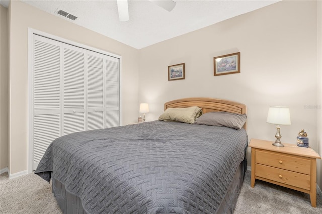 carpeted bedroom featuring ceiling fan and a closet