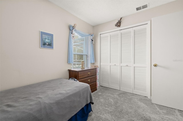 carpeted bedroom featuring a closet and a textured ceiling