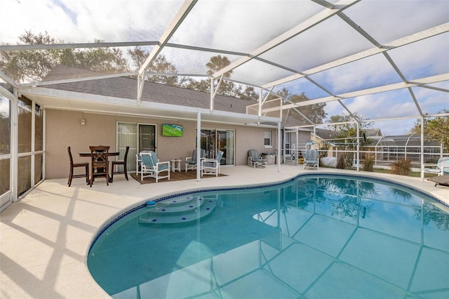 view of pool featuring glass enclosure and a patio area