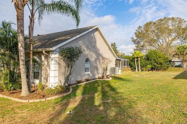 view of side of home with cooling unit and a yard