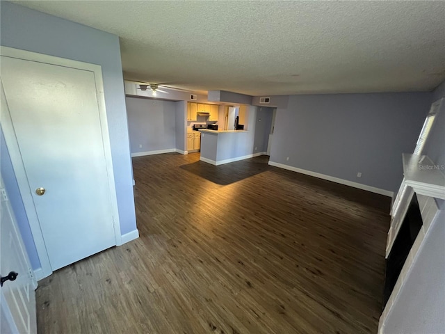 unfurnished living room with ceiling fan, dark hardwood / wood-style floors, and a textured ceiling