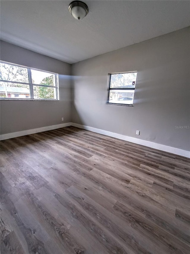 empty room with dark hardwood / wood-style flooring