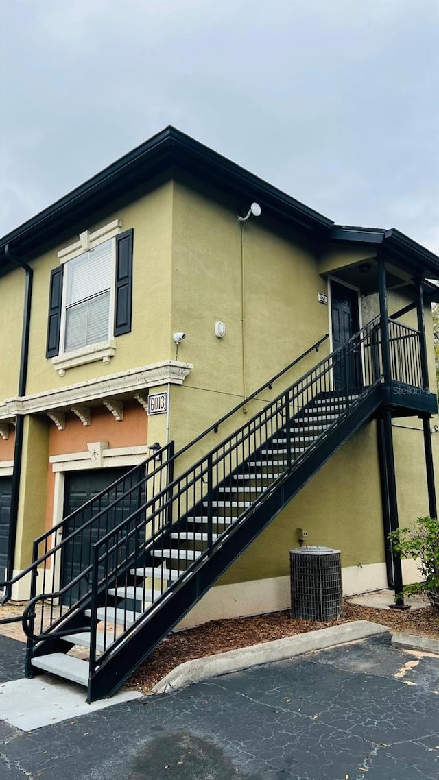 view of home's exterior with stucco siding and central AC unit