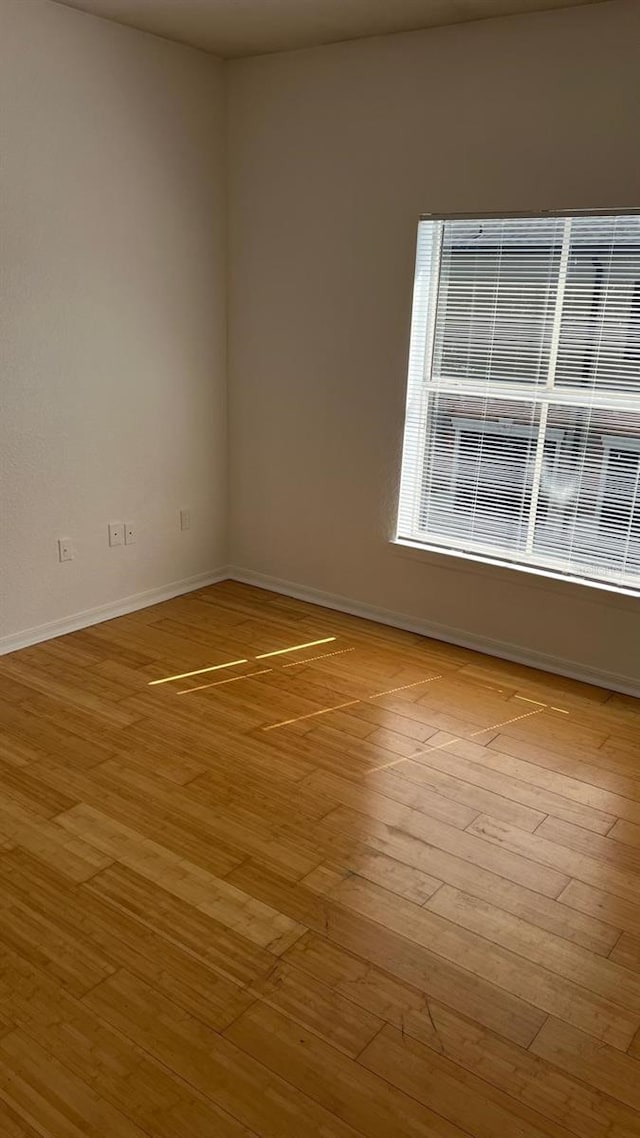 spare room with light wood finished floors and baseboards