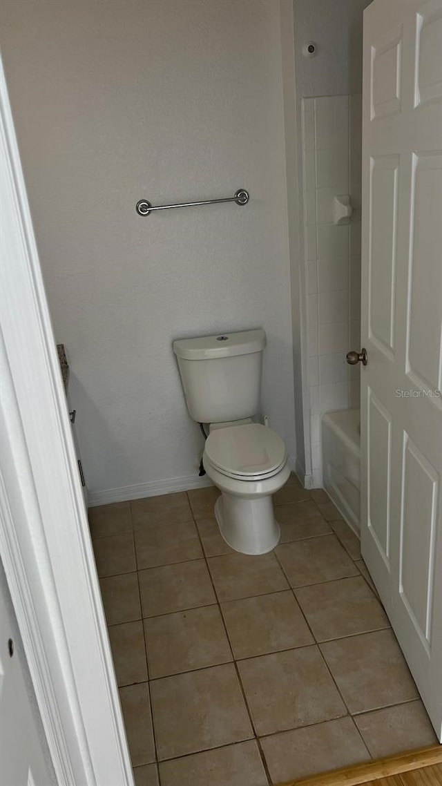 bathroom featuring tile patterned flooring, toilet, and baseboards