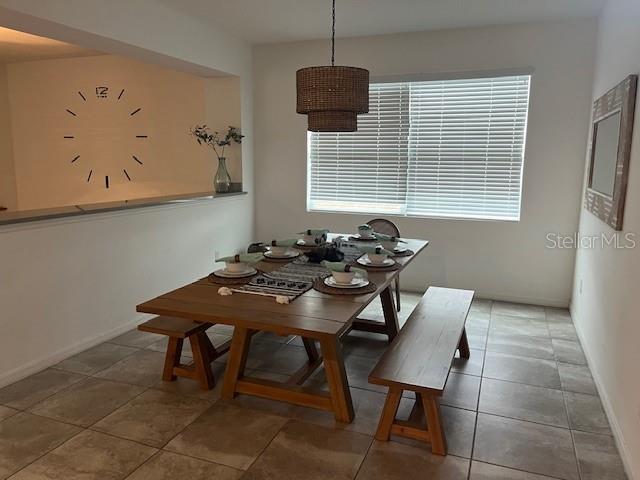 dining space with baseboards and tile patterned floors