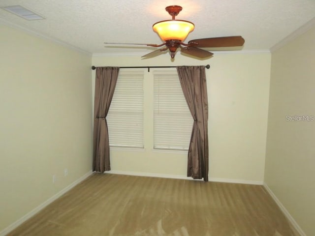 spare room with visible vents, baseboards, ornamental molding, wood finished floors, and a textured ceiling