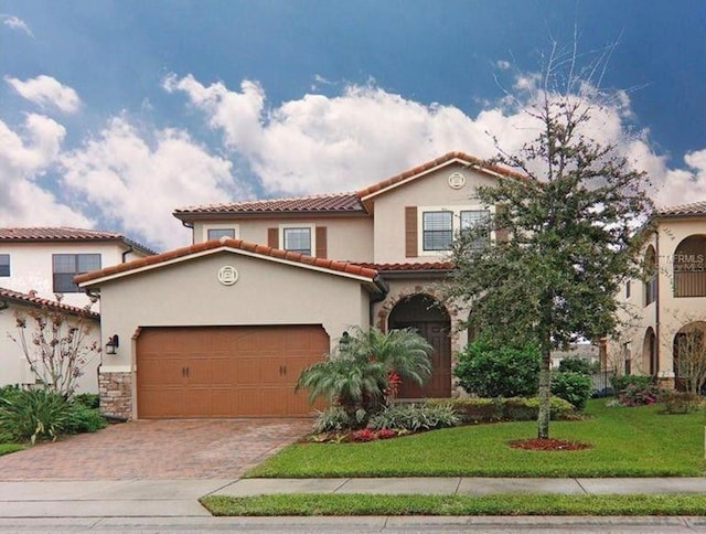 mediterranean / spanish home with a garage and a front yard