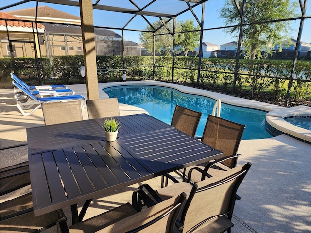 view of pool featuring an in ground hot tub, glass enclosure, and a patio area