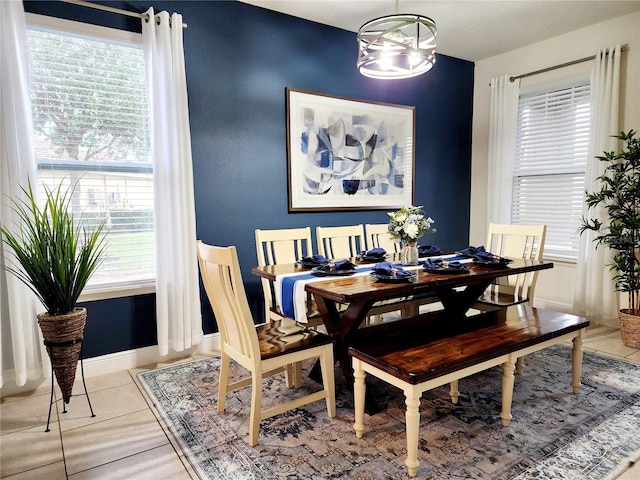 dining area featuring light tile patterned floors, plenty of natural light, and a chandelier