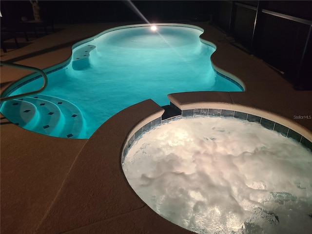 view of swimming pool featuring an in ground hot tub