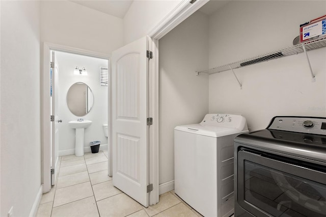 washroom featuring light tile patterned floors and washing machine and dryer