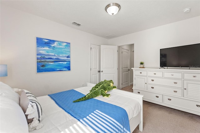 bedroom featuring light carpet and a textured ceiling