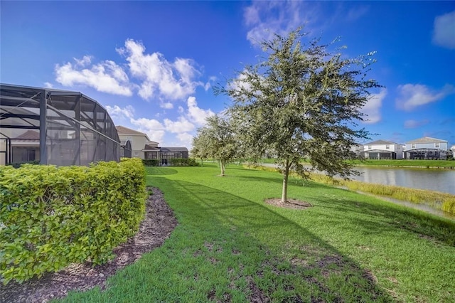 view of yard with a water view and a lanai