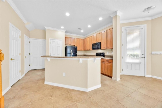 1518 Orrington Payne Pl, Casselberry, FL 32707 - kitchen featuring a breakfast bar, light tile patterned flooring, crown molding, black appliances, and a center island with sink