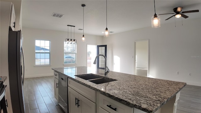 kitchen with sink, an island with sink, white cabinets, and appliances with stainless steel finishes