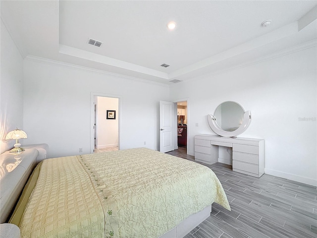 bedroom with a raised ceiling and crown molding