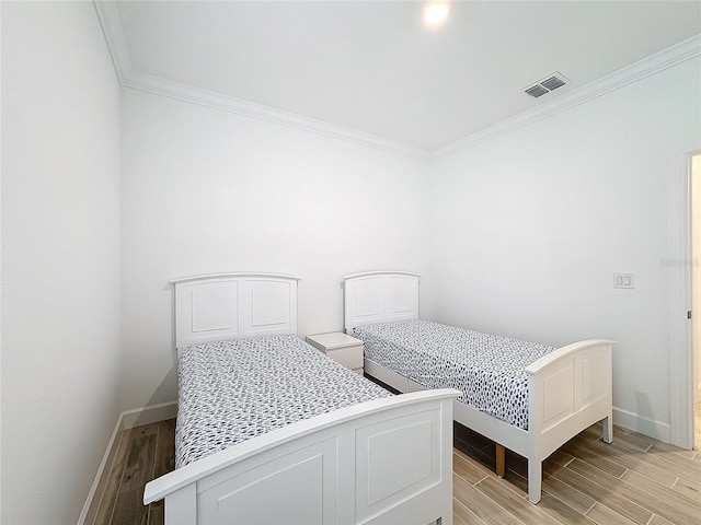 bedroom with light hardwood / wood-style flooring and crown molding