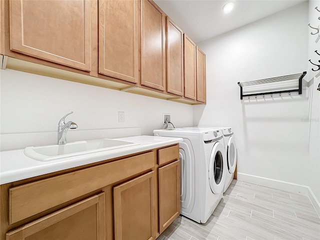 laundry area featuring sink, cabinets, and independent washer and dryer