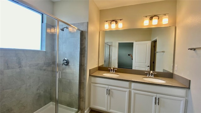 full bath with a stall shower, a sink, and double vanity