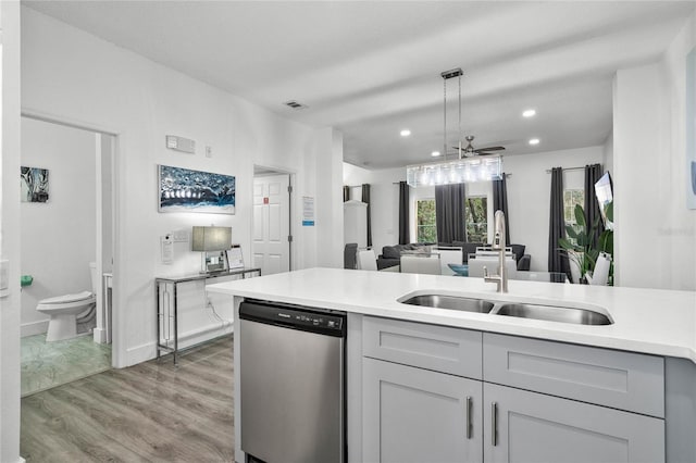 kitchen with sink, light hardwood / wood-style flooring, dishwasher, gray cabinetry, and decorative light fixtures