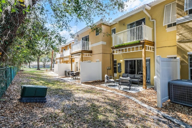 rear view of property featuring an outdoor living space, central AC, and a patio area