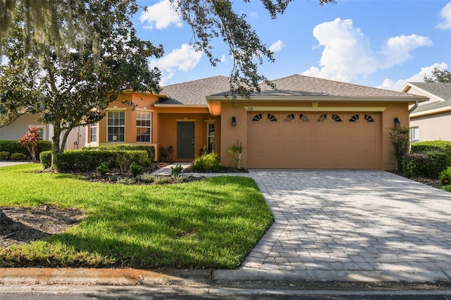 ranch-style home with a garage, a front lawn, decorative driveway, and stucco siding