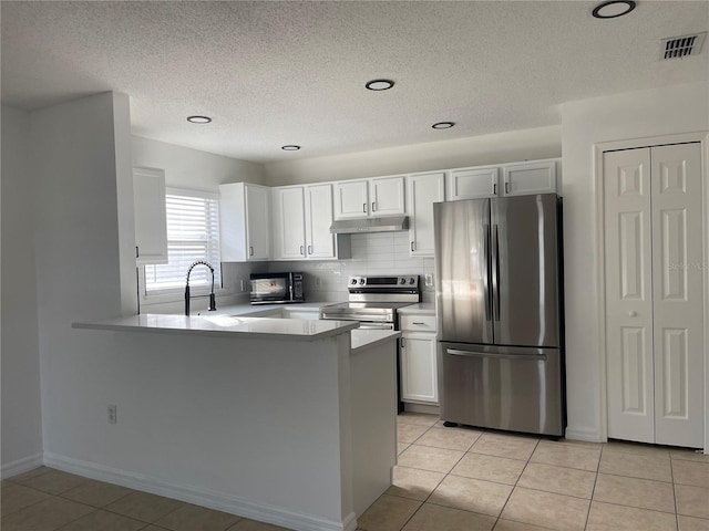 kitchen featuring stainless steel appliances, light tile patterned flooring, sink, white cabinetry, and kitchen peninsula