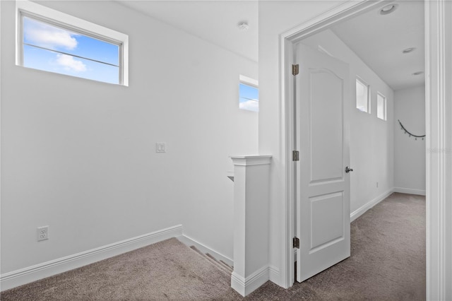 hall with baseboards and carpet flooring