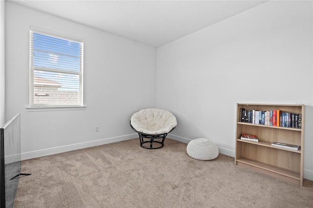 living area featuring carpet flooring and baseboards