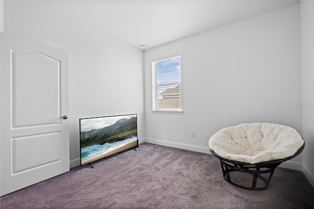 sitting room featuring carpet flooring and baseboards