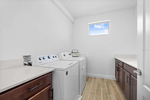 washroom with washer and clothes dryer, cabinet space, baseboards, and wood tiled floor