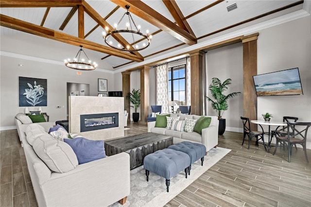 living room with visible vents, baseboards, wood tiled floor, a tiled fireplace, and beamed ceiling