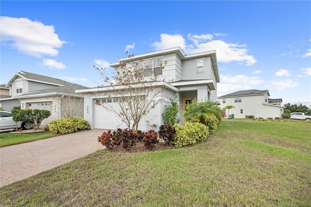 view of front of property with decorative driveway, an attached garage, a front yard, and stucco siding