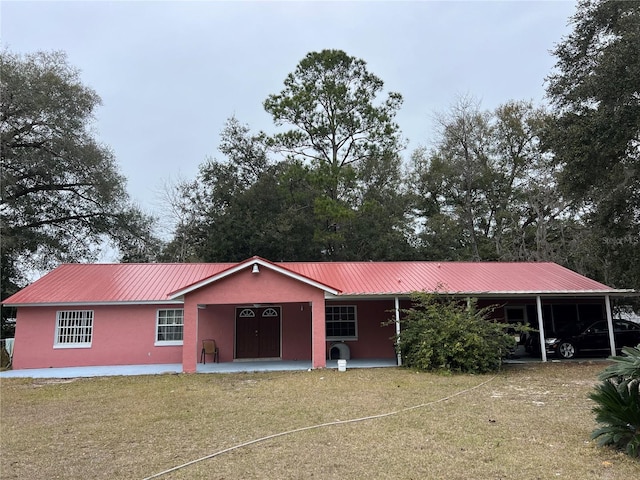 ranch-style home featuring a carport and a front yard