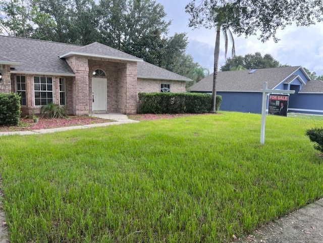 single story home featuring a front lawn