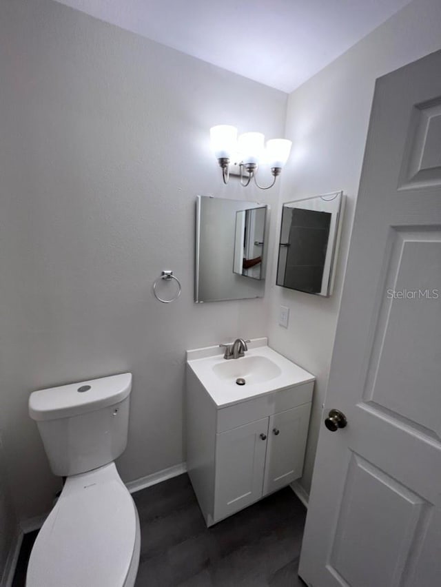 bathroom featuring vanity, toilet, and a notable chandelier