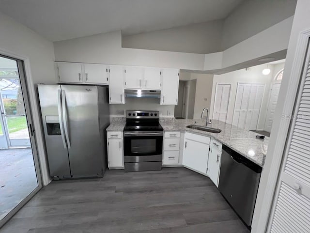 kitchen with appliances with stainless steel finishes, white cabinetry, sink, dark hardwood / wood-style flooring, and light stone counters