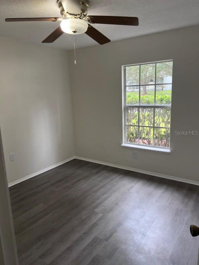 spare room with ceiling fan, dark hardwood / wood-style floors, and a textured ceiling