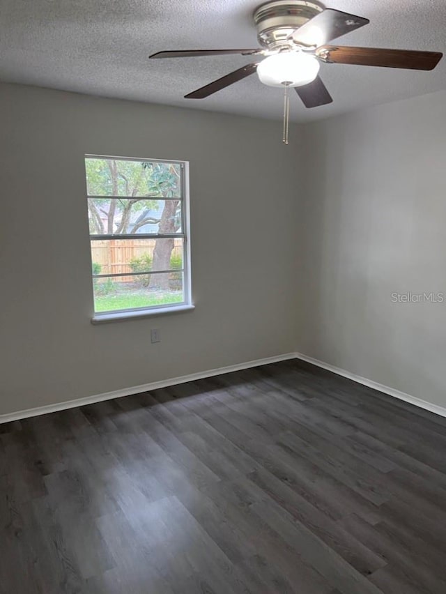 spare room featuring dark hardwood / wood-style floors and a textured ceiling