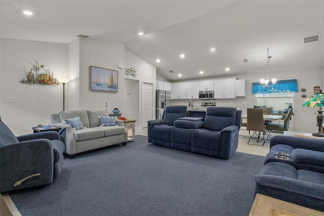 living area featuring high vaulted ceiling, recessed lighting, visible vents, and a notable chandelier